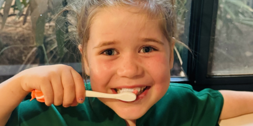 a girl is brushing her teeth