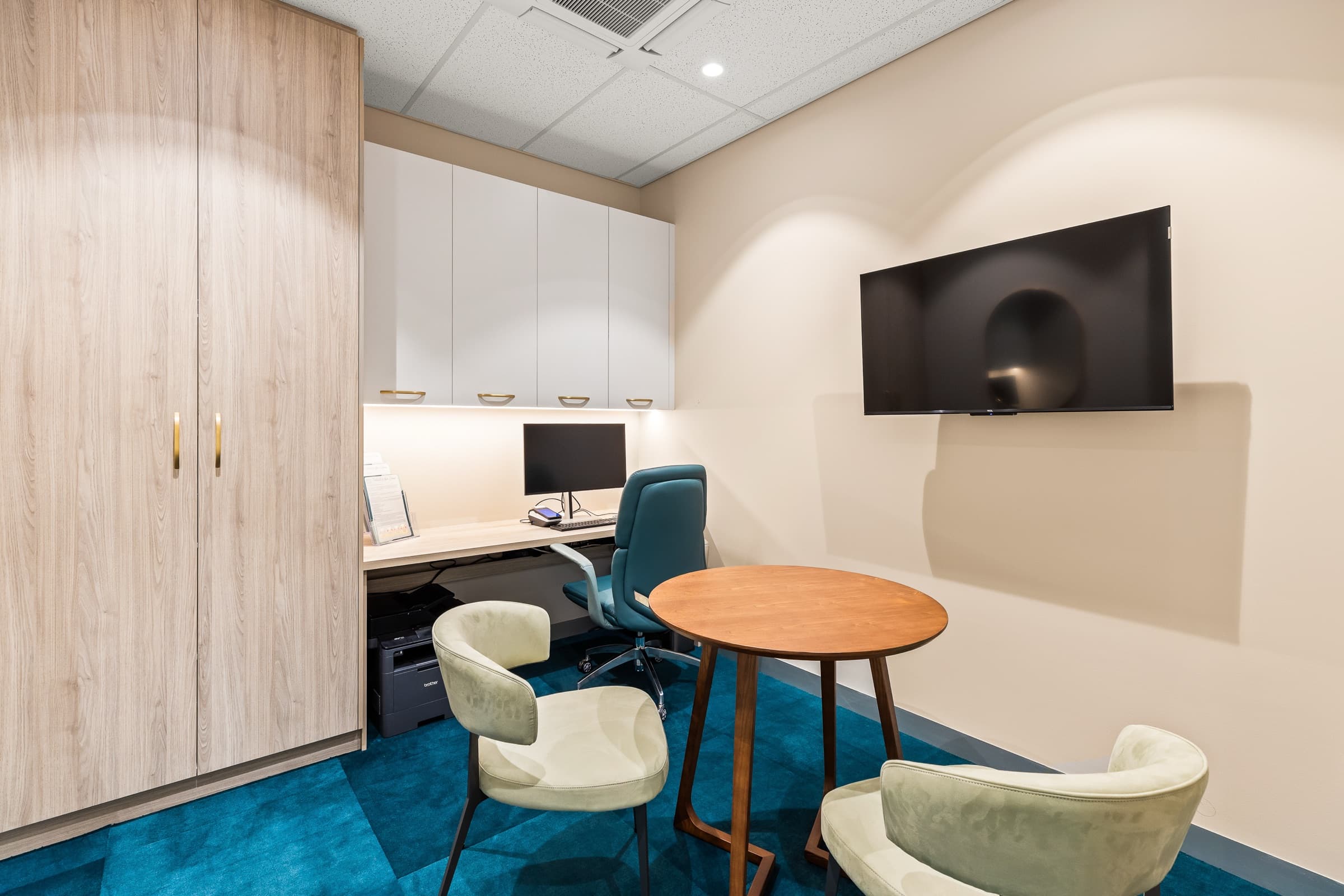 A private consultation room at DNTL Code with a round table and a wall screen