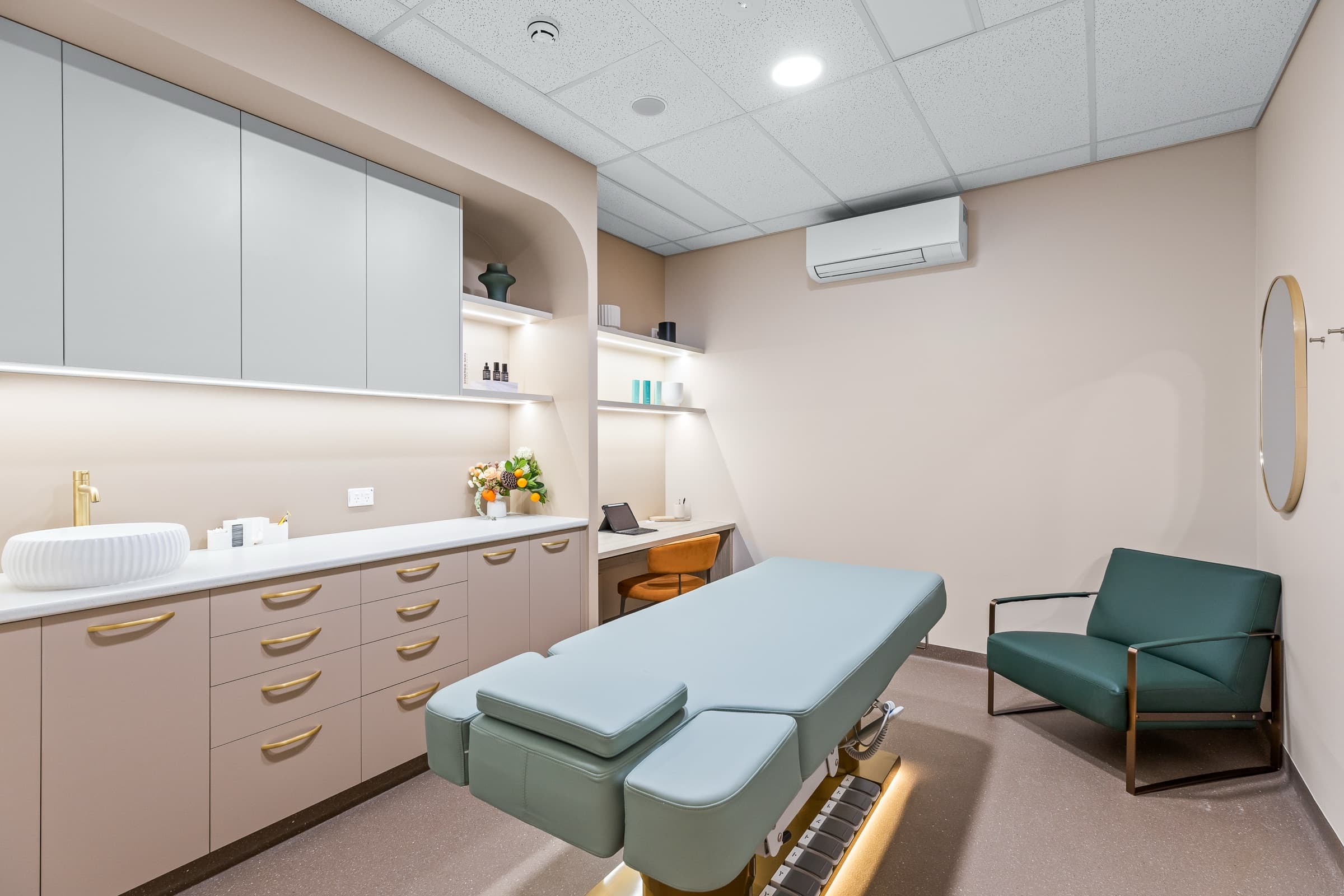 DNTL Code skin treatment room with a treatment bed and green armchair