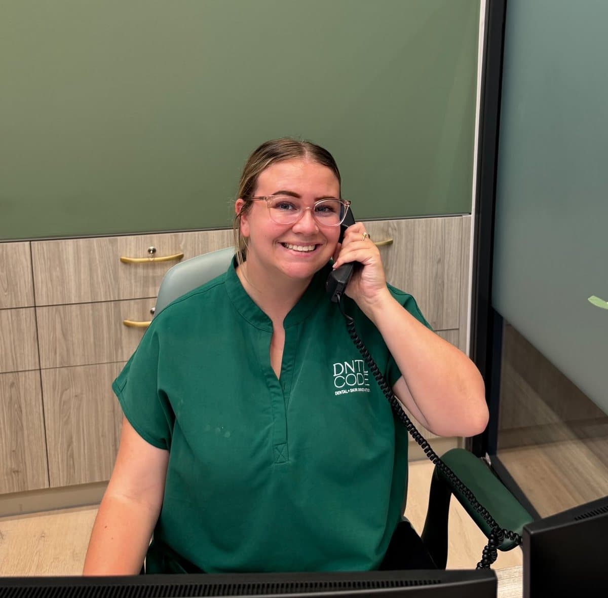 A member of our front desk team on the phone at DNTL Code reception