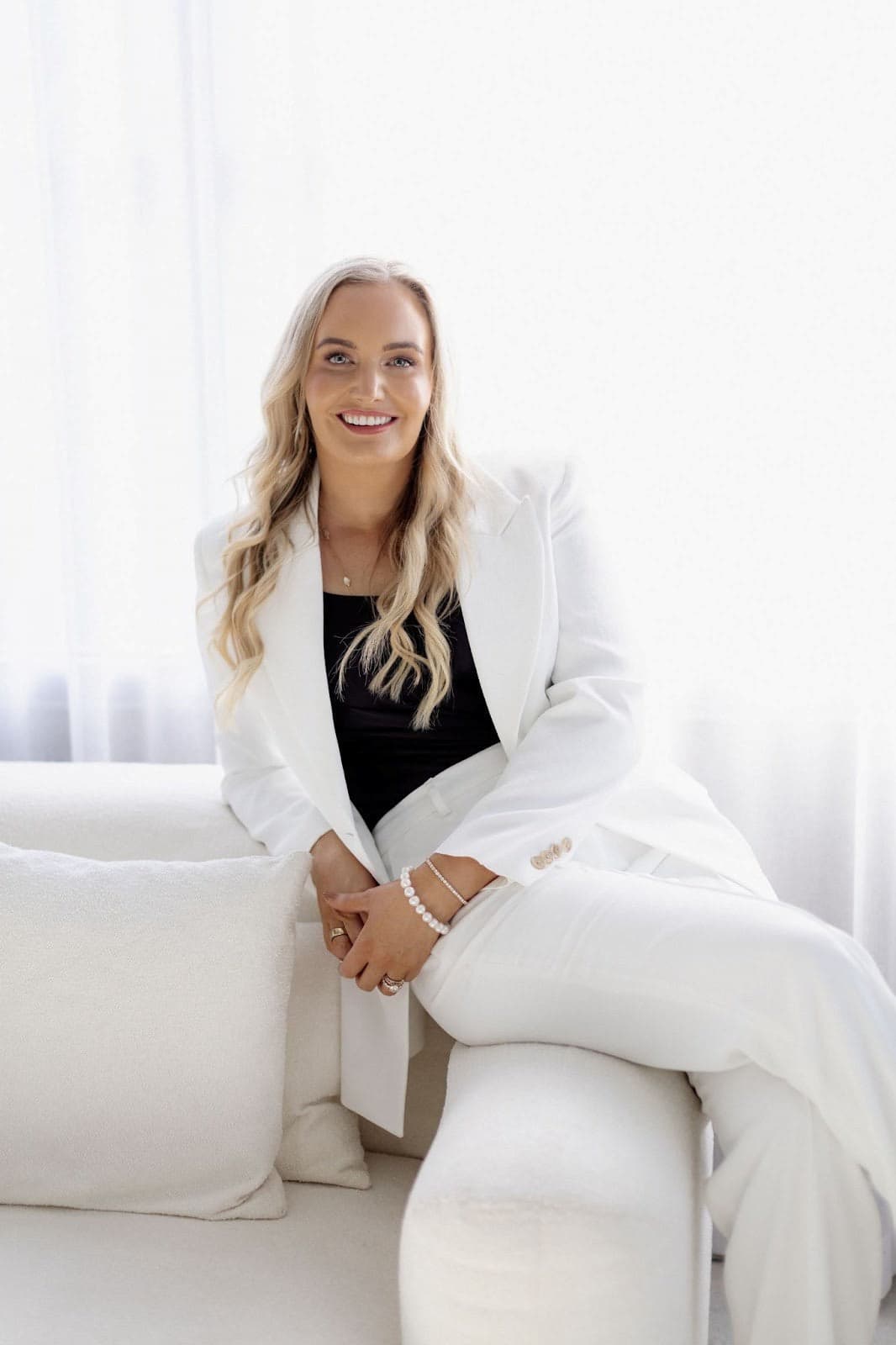 Dr Steph Mulcahy seated, wearing a white suit