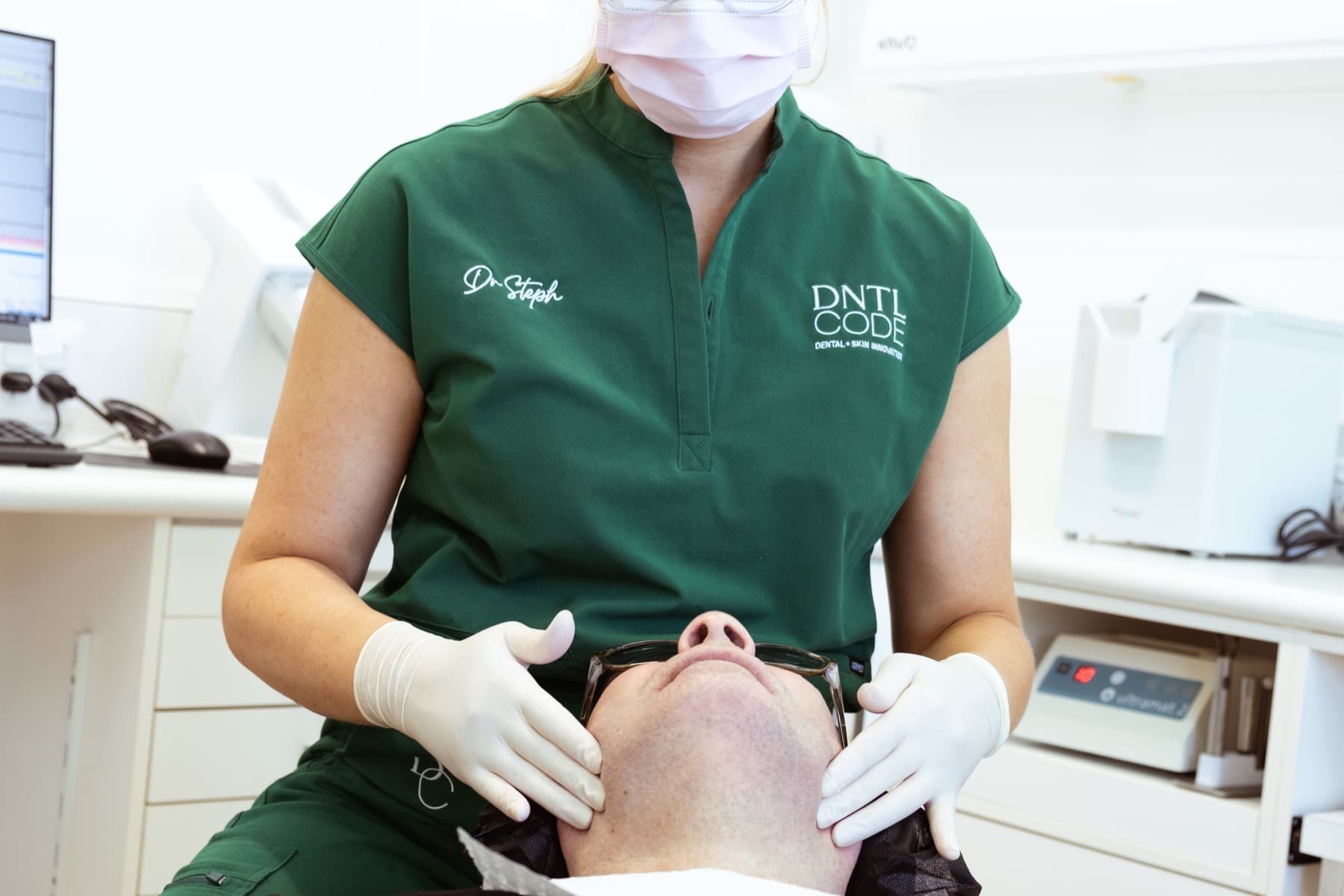 Clinician in DNTL Code scrubs treating a patient
