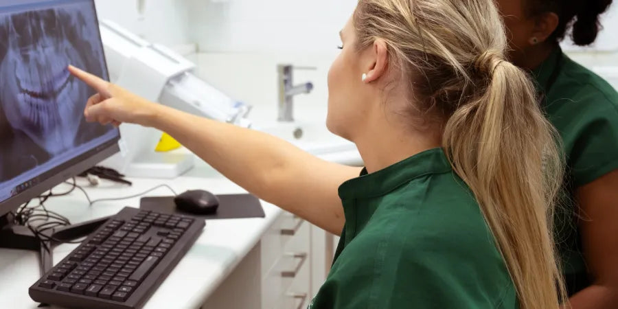 Clinician pointing at a dental scan on screen