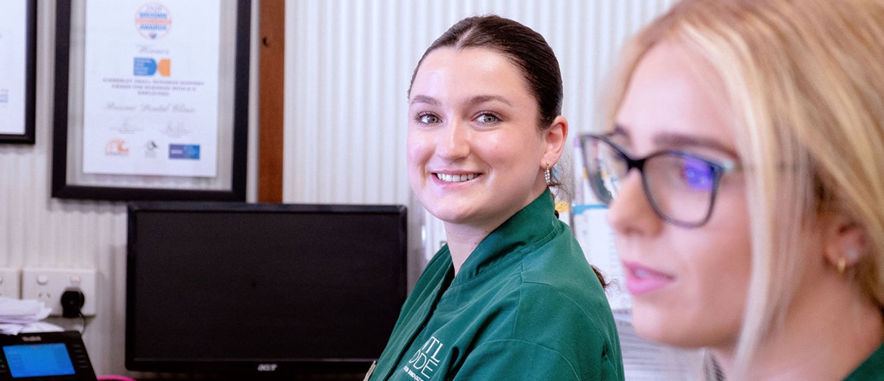 Two DNTL Code team members smiling at reception