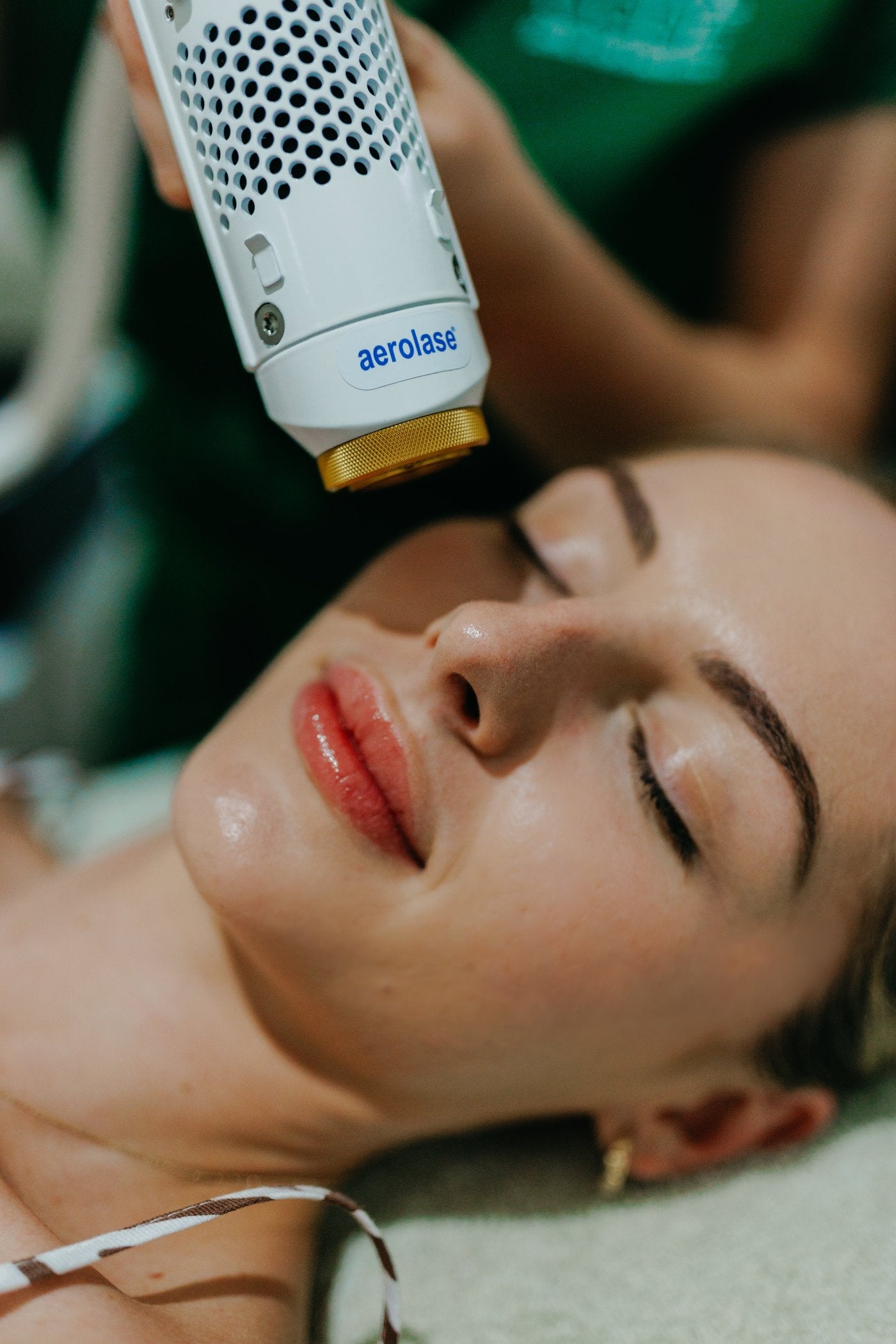 a girl getting treatment from aerolase machine in dntl code clinic