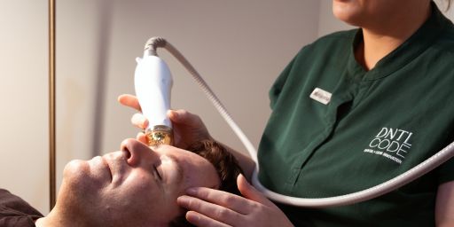 Clinician using a microneedling device on a client’s forehead